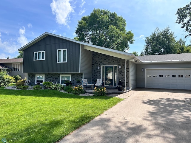 1908 23rd St S, Fargo, ND 58103 - tri-level home with a garage, concrete driveway, and a front lawn