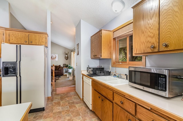 7230 Clear Rdg, Centerville, MN 55038 - kitchen featuring white appliances, lofted ceiling, light countertops, stone finish flooring, and brown cabinets