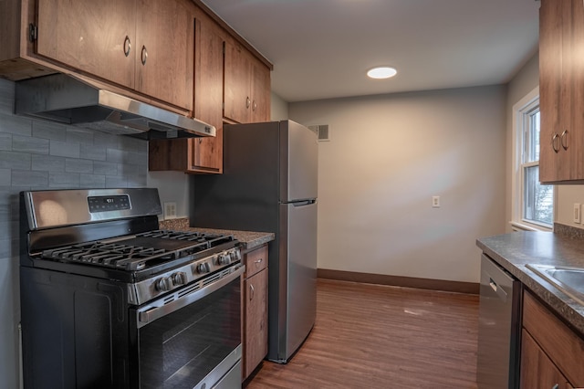 3708 Xenia Ave N, Crystal, MN 55422 - kitchen with stainless steel appliances, wood finished floors, under cabinet range hood, brown cabinetry, and recessed lighting