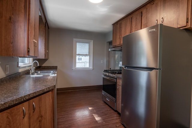 3708 Xenia Ave N, Crystal, MN 55422 - kitchen featuring appliances with stainless steel finishes, dark countertops, dark wood-type flooring, under cabinet range hood, and brown cabinetry