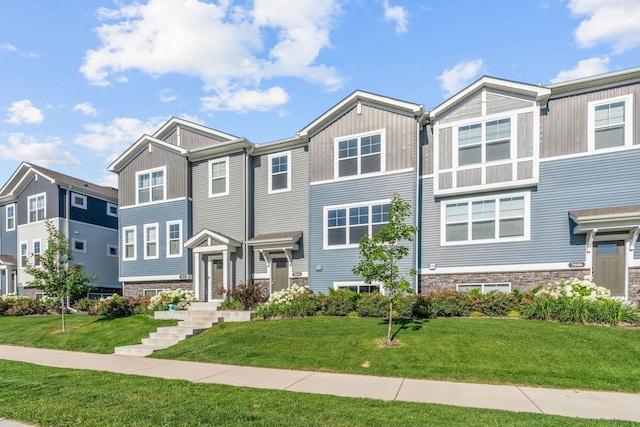 7614 Connie Ln, Inver Grove Heights, MN 55076 - townhome / multi-family property featuring a front lawn, stone siding, and board and batten siding