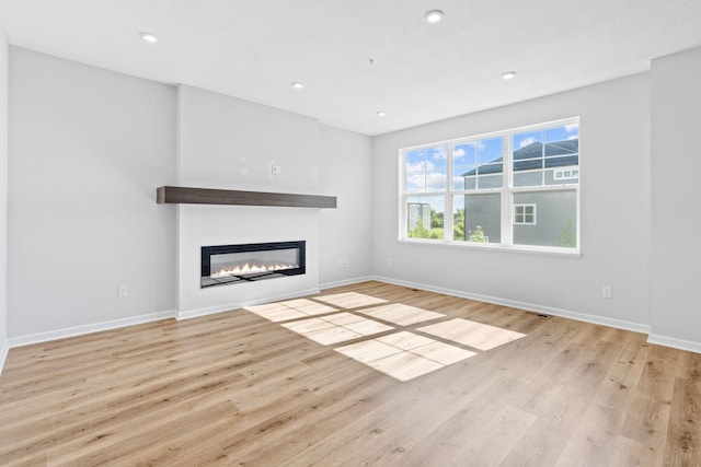 7614 Connie Ln, Inver Grove Heights, MN 55076 - unfurnished living room with a glass covered fireplace, wood finished floors, and recessed lighting