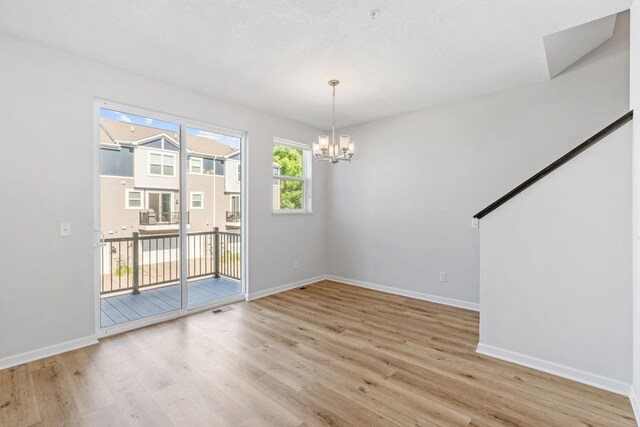7614 Connie Ln, Inver Grove Heights, MN 55076 - spare room featuring light wood-style floors and a chandelier