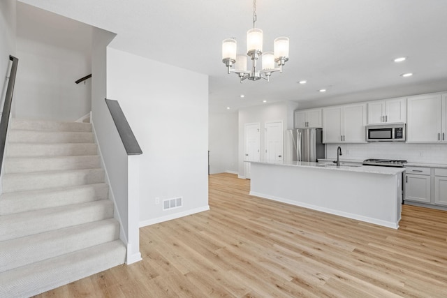 7614 Connie Ln, Inver Grove Heights, MN 55076 - kitchen with appliances with stainless steel finishes, light wood finished floors, recessed lighting, a chandelier, and backsplash