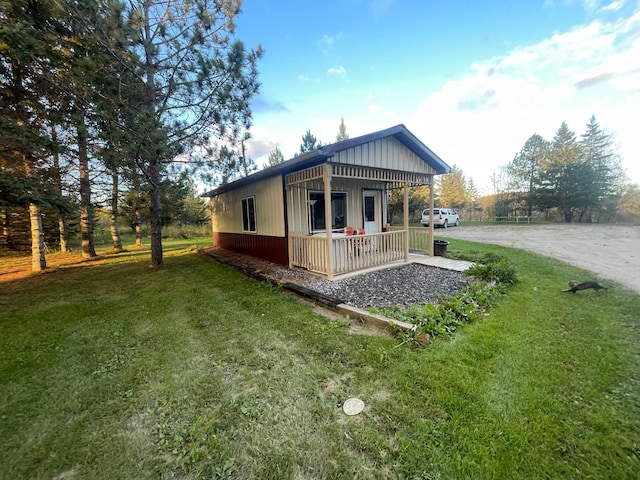 656 22nd Ave NW, Baudette Twp, MN 56623 - view of side of property featuring a porch, a lawn, driveway, and board and batten siding