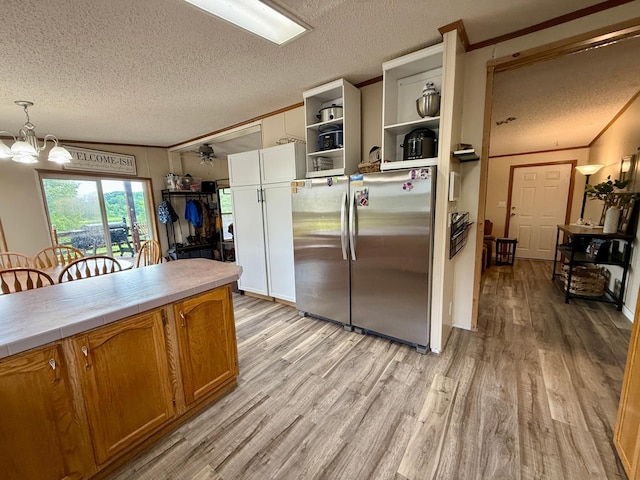 656 22nd Ave NW, Baudette Twp, MN 56623 - kitchen with freestanding refrigerator, tile counters, a textured ceiling, open shelves, and light wood-type flooring
