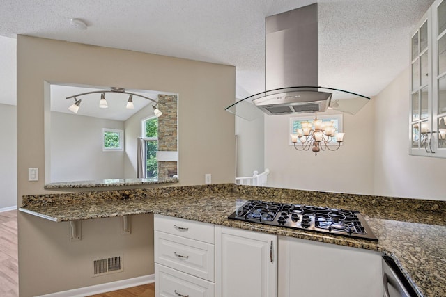14170 Westridge Dr, Eden Prairie, MN 55347 - kitchen with island range hood, black gas stovetop, glass insert cabinets, a chandelier, and white cabinetry
