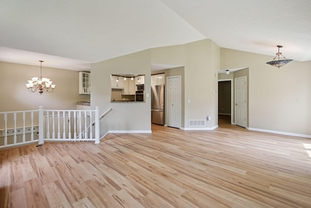 14170 Westridge Dr, Eden Prairie, MN 55347 - spare room with a chandelier, light wood-style floors, and lofted ceiling