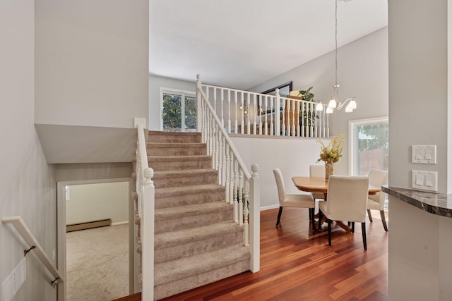 549 Vicki Ln, Shoreview, MN 55126 - staircase featuring a baseboard radiator, a high ceiling, wood finished floors, and a chandelier