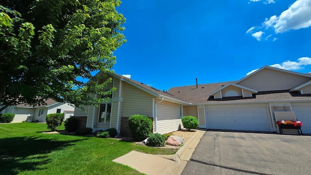 9136 Windsor Ter, Brooklyn Park, MN 55443 - view of front of house with a front yard, roof with shingles, asphalt driveway, and a garage