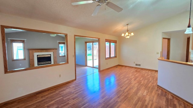 9136 Windsor Ter, Brooklyn Park, MN 55443 - unfurnished living room featuring wood finished floors, lofted ceiling, a fireplace, a ceiling fan, and a chandelier
