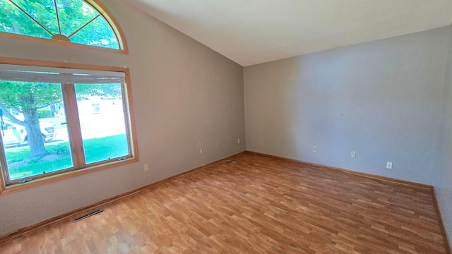 9136 Windsor Ter, Brooklyn Park, MN 55443 - empty room featuring vaulted ceiling, healthy amount of natural light, and light wood-style floors