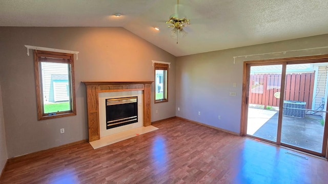 9136 Windsor Ter, Brooklyn Park, MN 55443 - unfurnished living room with wood finished floors, vaulted ceiling, healthy amount of natural light, a ceiling fan, and a fireplace with flush hearth