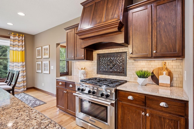 7461 Merrimac Ln N, Maple Grove, MN 55311 - kitchen featuring stainless steel stove, custom exhaust hood, plenty of natural light, tasteful backsplash, and recessed lighting