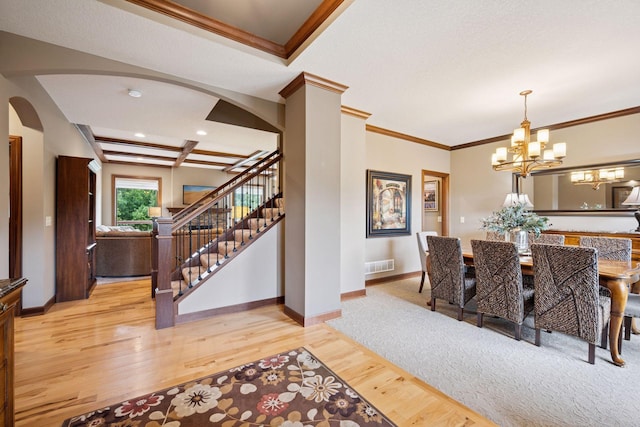 7461 Merrimac Ln N, Maple Grove, MN 55311 - dining room with arched walkways, light wood finished floors, stairway, ornamental molding, and a chandelier
