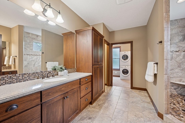 7461 Merrimac Ln N, Maple Grove, MN 55311 - bathroom featuring estacked washer and dryer, vanity, a walk in shower, and tasteful backsplash