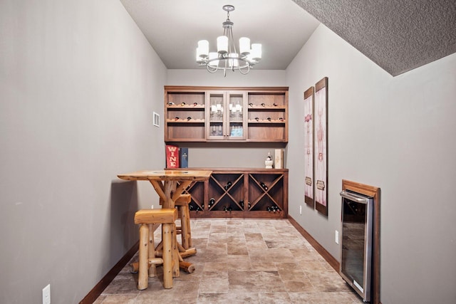 7461 Merrimac Ln N, Maple Grove, MN 55311 - wine room with a chandelier, stone finish flooring, and beverage cooler