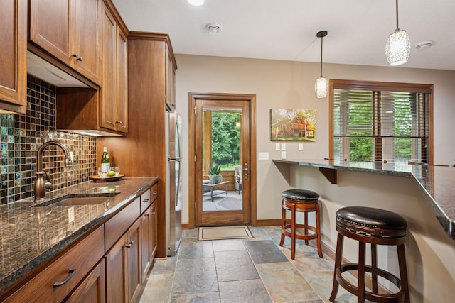 7461 Merrimac Ln N, Maple Grove, MN 55311 - kitchen featuring freestanding refrigerator, decorative backsplash, brown cabinets, and plenty of natural light