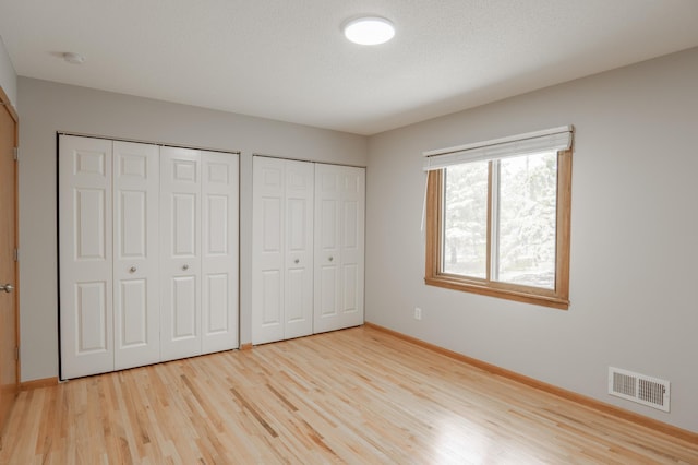 1781 Taconite Pt, Eagan, MN 55122 - unfurnished bedroom featuring two closets and light wood-style floors