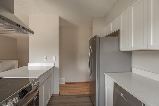 1781 Taconite Pt, Eagan, MN 55122 - kitchen featuring wall chimney exhaust hood, appliances with stainless steel finishes, white cabinets, wood finished floors, and light countertops
