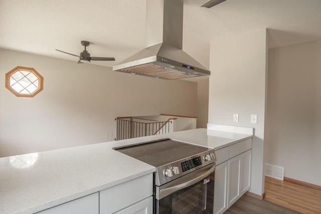 1781 Taconite Pt, Eagan, MN 55122 - kitchen featuring wall chimney range hood, stainless steel electric range, light wood finished floors, ceiling fan, and white cabinetry