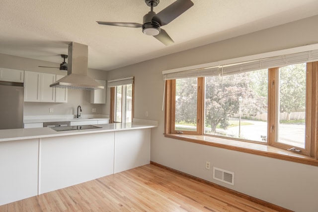 1781 Taconite Pt, Eagan, MN 55122 - kitchen featuring island exhaust hood, a ceiling fan, freestanding refrigerator, light countertops, and white cabinetry