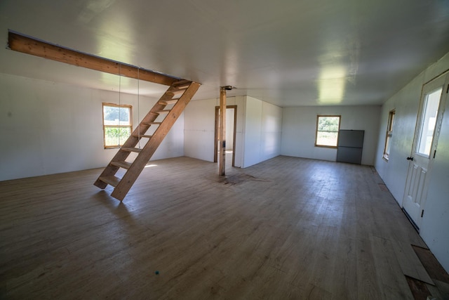 43724 County Highway 19, Blowers Twp, MN 56477 - unfurnished living room with wood finished floors, healthy amount of natural light, and stairway