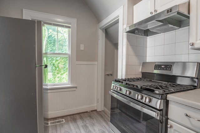 4020 Emerson Ave N, Minneapolis, MN 55412 - kitchen featuring appliances with stainless steel finishes, ventilation hood, light wood-type flooring, white cabinets, and decorative backsplash