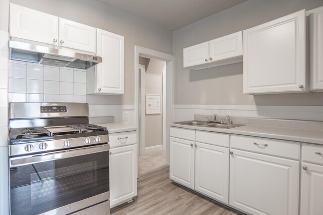 4020 Emerson Ave N, Minneapolis, MN 55412 - kitchen with stainless steel gas stove, under cabinet range hood, white cabinets, light countertops, and light wood-style flooring