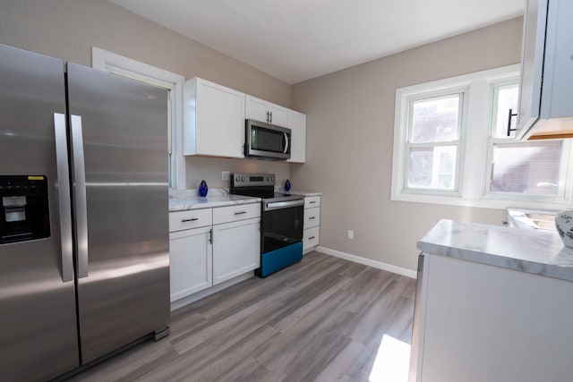 1702 Minnehaha Ave W, Saint Paul, MN 55104 - kitchen with stainless steel appliances, white cabinets, and light wood-type flooring