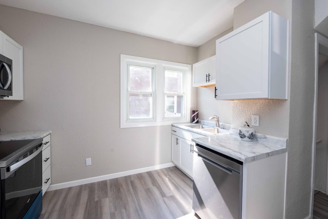 1702 Minnehaha Ave W, Saint Paul, MN 55104 - kitchen featuring stainless steel appliances, light wood-type flooring, and white cabinetry