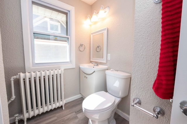 1702 Minnehaha Ave W, Saint Paul, MN 55104 - bathroom featuring radiator heating unit, wood finished floors, vanity, and a textured wall