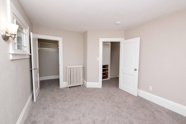 1702 Minnehaha Ave W, Saint Paul, MN 55104 - unfurnished bedroom with radiator, carpet floors, and a walk in closet