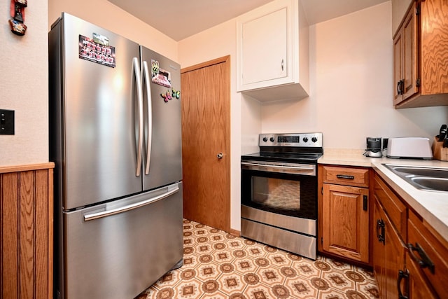 1314 Parkview Ave, Winona, MN 55987 - kitchen with appliances with stainless steel finishes, light countertops, brown cabinetry, and light flooring