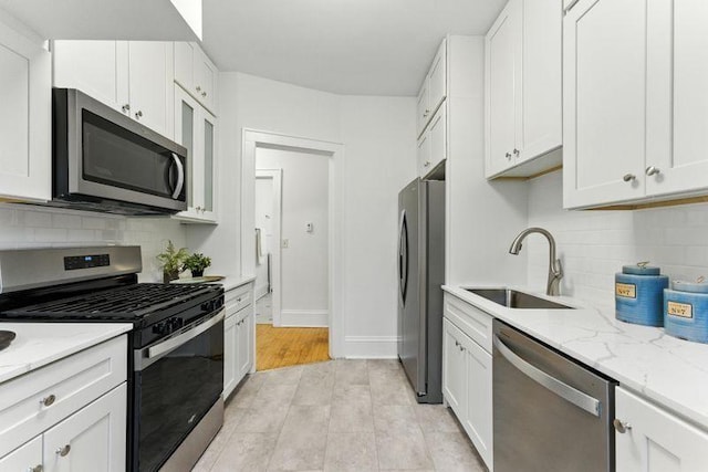 3148 Bryant Ave S, Minneapolis, MN 55408 - kitchen featuring stainless steel appliances, white cabinetry, tasteful backsplash, and light stone countertops