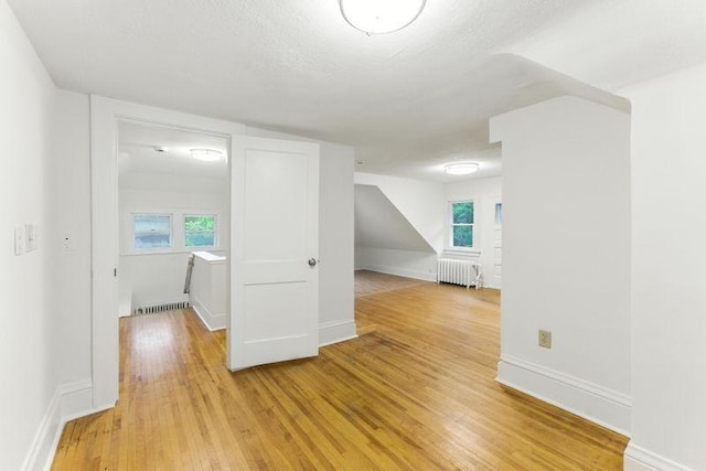 3148 Bryant Ave S, Minneapolis, MN 55408 - unfurnished room with radiator heating unit, light wood-style flooring, and a textured ceiling