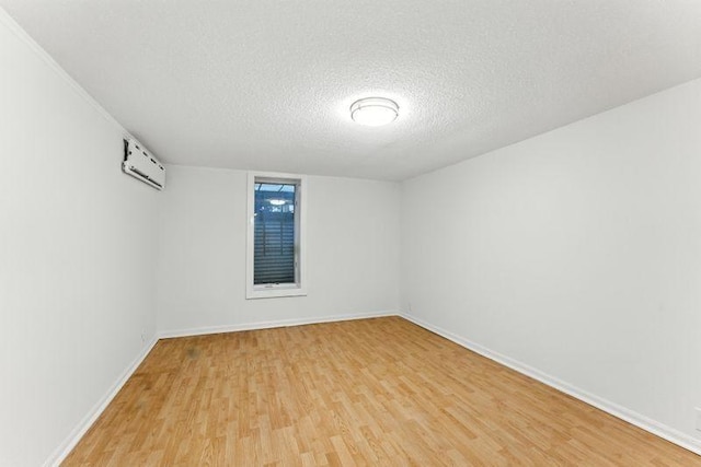 3148 Bryant Ave S, Minneapolis, MN 55408 - empty room with light wood-style floors, a textured ceiling, and an AC wall unit