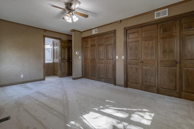 41072 280th St, Arlington Twp, MN 55307 - unfurnished bedroom with carpet flooring, multiple closets, ornamental molding, ceiling fan, and ensuite bathroom
