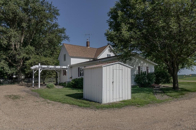 41072 280th St, Arlington Twp, MN 55307 - view of side of home with a pergola, a shed, a yard, and a chimney