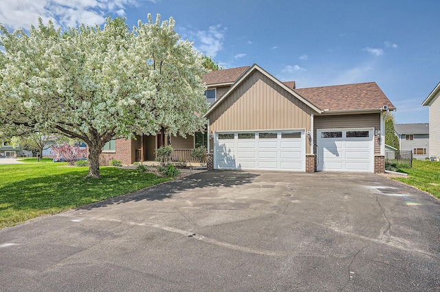 2907 Asarum Ct, Shakopee, MN 55379 - view of front facade with brick siding, asphalt driveway, an attached garage, a front lawn, and a shingled roof