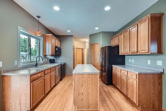2907 Asarum Ct, Shakopee, MN 55379 - kitchen featuring black microwave, a textured ceiling, freestanding refrigerator, a center island, and dishwasher