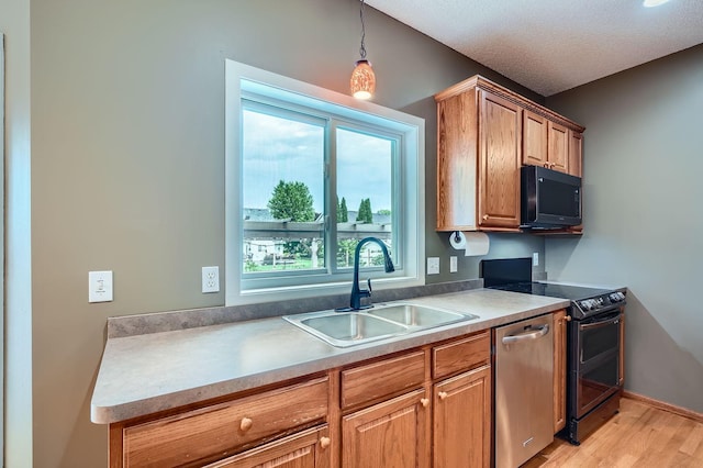 2907 Asarum Ct, Shakopee, MN 55379 - kitchen featuring stainless steel dishwasher, black microwave, light wood-style floors, and plenty of natural light