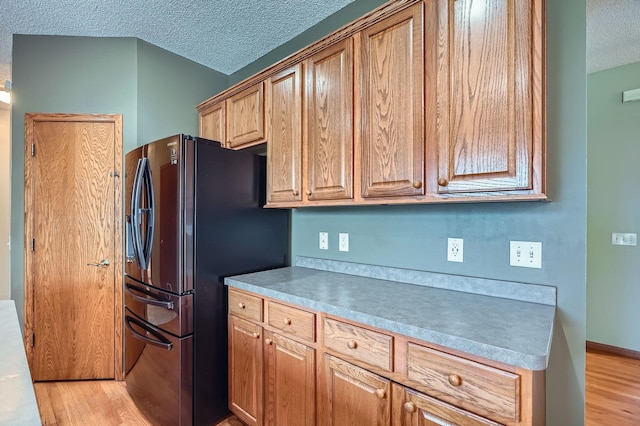 2907 Asarum Ct, Shakopee, MN 55379 - kitchen with freestanding refrigerator, a textured ceiling, light wood-style floors, and light countertops