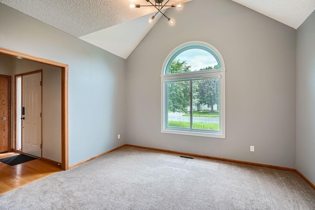 2907 Asarum Ct, Shakopee, MN 55379 - unfurnished room with carpet floors, healthy amount of natural light, vaulted ceiling, and a chandelier