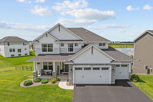 5027 Jansen Ave NE, Saint Michael, MN 55376 - craftsman-style house with a shingled roof, board and batten siding, stone siding, asphalt driveway, and a porch