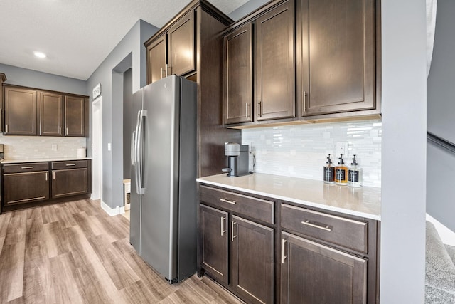 5027 Jansen Ave NE, Saint Michael, MN 55376 - kitchen with freestanding refrigerator, light wood finished floors, light countertops, dark brown cabinets, and decorative backsplash
