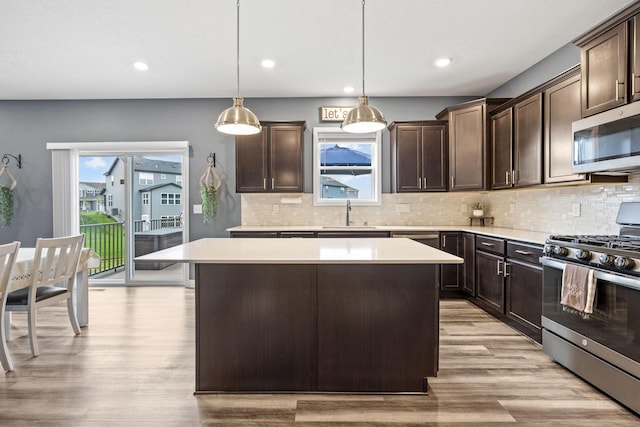 5027 Jansen Ave NE, Saint Michael, MN 55376 - kitchen with stainless steel appliances, a center island, dark brown cabinets, light wood-style floors, and light countertops
