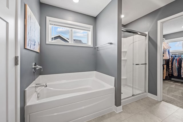 5027 Jansen Ave NE, Saint Michael, MN 55376 - bathroom featuring a garden tub, a shower stall, a walk in closet, and tile patterned floors