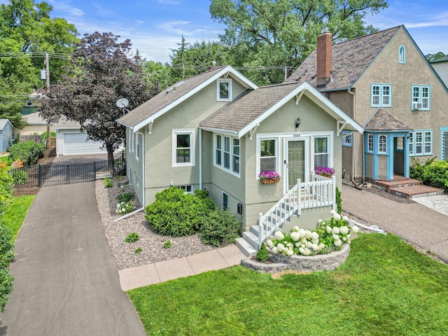 500 Otis Ave, Saint Paul, MN 55104 - view of front of home with stucco siding, a chimney, a detached garage, an outbuilding, and roof with shingles