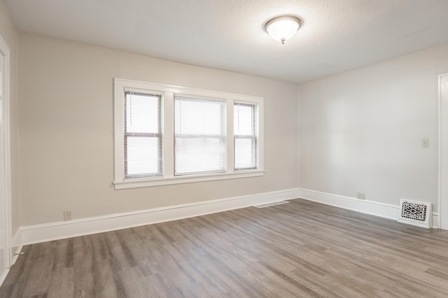 3919 Dupont Ave N, Minneapolis, MN 55412 - empty room with wood finished floors and a textured ceiling